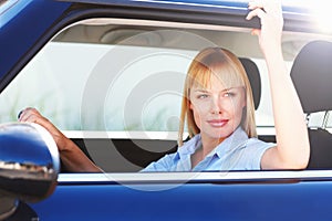 Day dreaming - Modern woman in the front seat of a car. Thoughtful young woman sitting in the front seat of a car.
