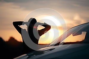 Silhouette of Happy Female Driver Next to her Car