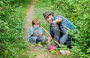 Day of earth. Boy and father in nature. Gardening tools. Planting flowers. Dad teaching little son care plants. Little