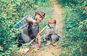 Day of earth. Boy and father in nature. Gardening tools. Planting flowers. Dad teaching little son care plants. Little