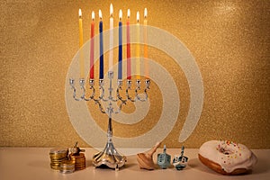 Day 7 of jewish  Hanukkah with traditional chandelier menorah, spinning top toys dreidels and a doughnut and ch