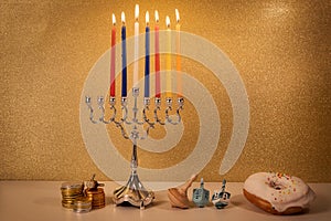 Day 6 of jewish holiday Hanukkah with traditional chandelier menorah, spinning top toys dreidels and a doughnut and ch