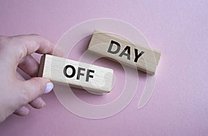 Day off symbol. Concept word Day off on wooden blocks. Businessman hand. Beautiful pink background. Business and Day off concept.