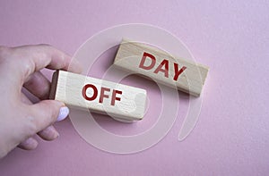 Day off symbol. Concept word Day off on wooden blocks. Businessman hand. Beautiful pink background. Business and Day off concept.