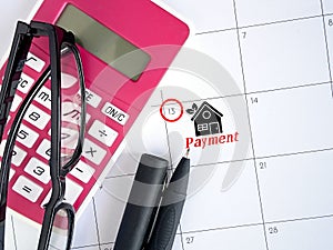 Day of payment for rent or loan. Calendar,pen, calculator,glasses and icon home with text paymen