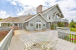 Day shot of a wonder California home with a large deck and seating area on a bright sunny day with puffy clouds photo