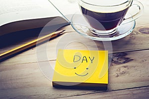 Day text with notepaper,notepad and coffee cup on desk