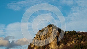 Day time lapse with moving clouds above picturesque rocks