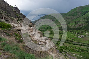 Day view of the caves in the mountain, river valley and blue sky. Vardzia is a cave monastery, an ancient rock-hewn town, was