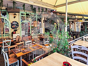 Day view of the empty traditional outdoor seating area of taverns with colorful chairs, tables and vintage decoration