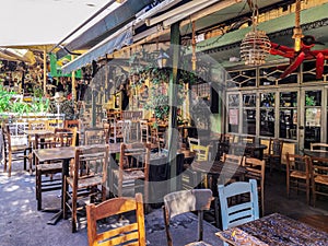 Day view of the empty traditional outdoor seating area of taverns with colorful chairs, tables and vintage decoration