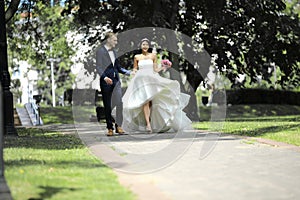 Day of the wedding the beautiful bride and groom walk through the park