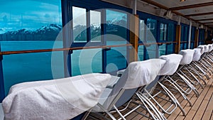 Daybeds in row. Window view to coastal landscape of fjords and glaciers from resort daybeds