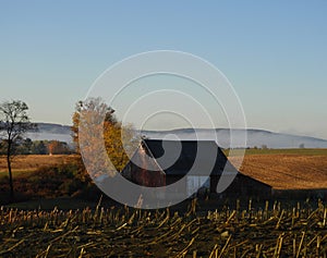 Daybreak over the farm, empty crop fields & valley fog