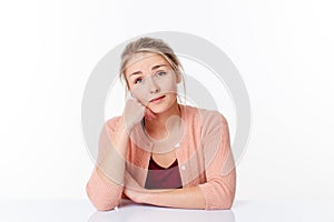 Daydreaming beautiful 20s blond woman sitting at sparse desk