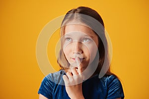 Daydreaming Little Girl Touching Mouth And Looking Up