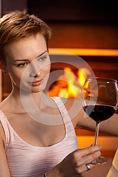 Daydreaming woman enjoying glass of wine