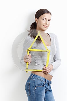 Daydreaming woman posing with folding rule