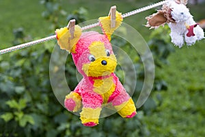 daylight. on a clothesline hanging soft children's toys. they are fixed with a clothespin