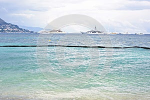 Daylight cloudy day view to beachline with ships cruising on water