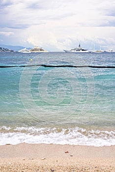 Daylight cloudy day view to beachline with ships cruising on water