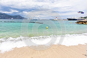 Daylight cloudy day view to beachline with ships cruising on water