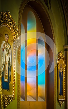 Daylight passes through a colorful stained glass window in the church