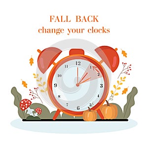 Daylight saving time concept.Alarm clock on the autumn leaves and pumpkins background. The reminder text - set clock back one