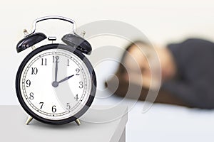 Daylight Saving Time, Spring forward. A clock watch with a person sleeping in the background photo