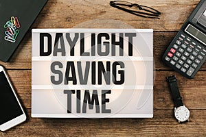 Daylight Saving Time in vintage style light box on office deskt