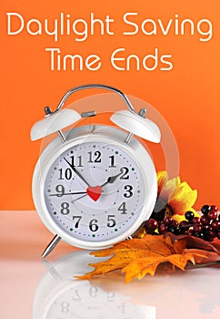 Daylight savings time ends in autumn fall with clock concept and text message