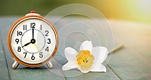 Daylight savings time, spring forward - alarm clock and easter flower banner