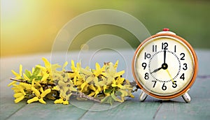 Daylight savings time, spring forward - banner of an alarm clock and flowers