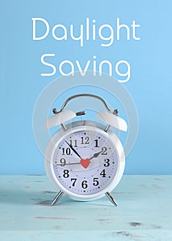 Daylight savings time white clock on a vintage aqua blue wood table photo