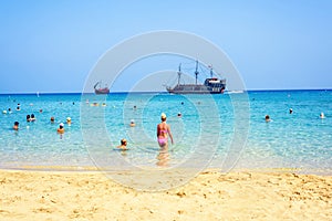 Daylight view from beachline to people watching two pirate ships