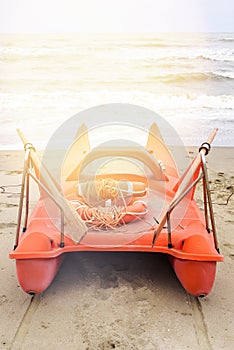 Daylight view to red boat parked on sand with two lifesavers