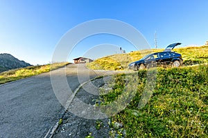 Daylight view to road to cottage with parked car on side.