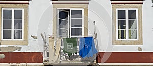 Daytime image of building facade with clothesline with 3 clothes to dry and 3 windows photo