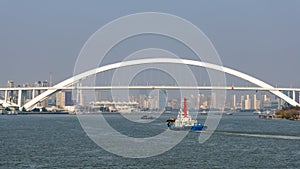 Daytime view of Huangpu River in Shanghai, China, with Lupu Bridge in the distance