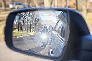 Dazzle lighting from riding motorcycle in side view mirror of car. Dazzling effect concept