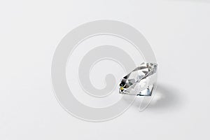 Dazzling diamond on neutral light background. Loose brilliant round diamond side view, copyspace