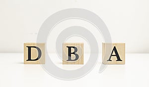 DBA a word written on wooden cubes on a white background