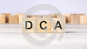 DCA - word concept written on wooden cubes or blocks on a light background