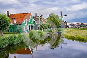 De Huisman windmill with Dutch houses and reflection