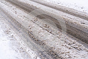 De-icing chemicals and sand on the snowy winter road