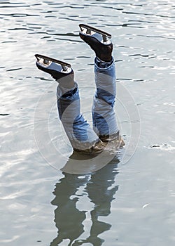 Dead ice skater head downwards in water photo