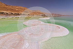 Dead Sea coastline with white salt and mountains in Ein Bokek, Israel