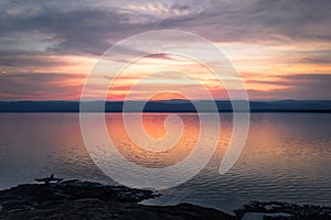 Dead Sea - October 05, 2018: Tourists bathing in the salty Dead Sea by sunset, Jordan