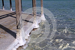 Dead Sea. Salt formation on stilts wooden bridge