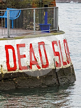 Dead Slow warning sign at the entrance to Paignton Harbour in Devon